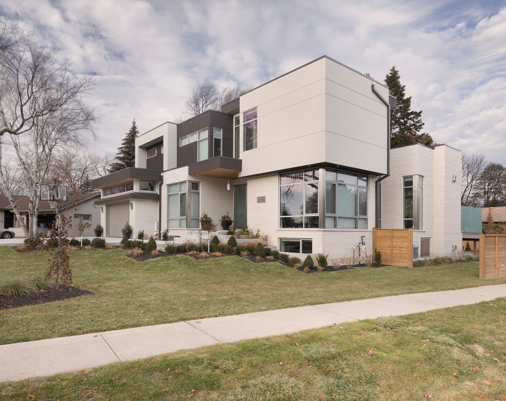 Inspiration for a large modern white two-story stone exterior home remodel in Toronto