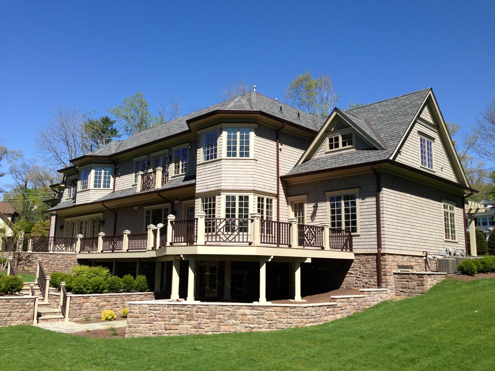 Inspiration for a large timeless beige two-story mixed siding exterior home remodel in New York
