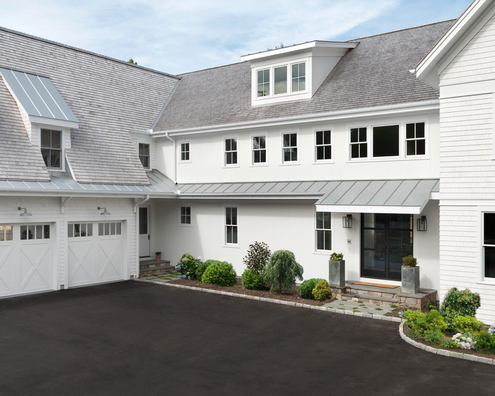 Réalisation d'une grande façade de maison blanche champêtre en bois à un étage avec un toit mixte et un toit à deux pans.