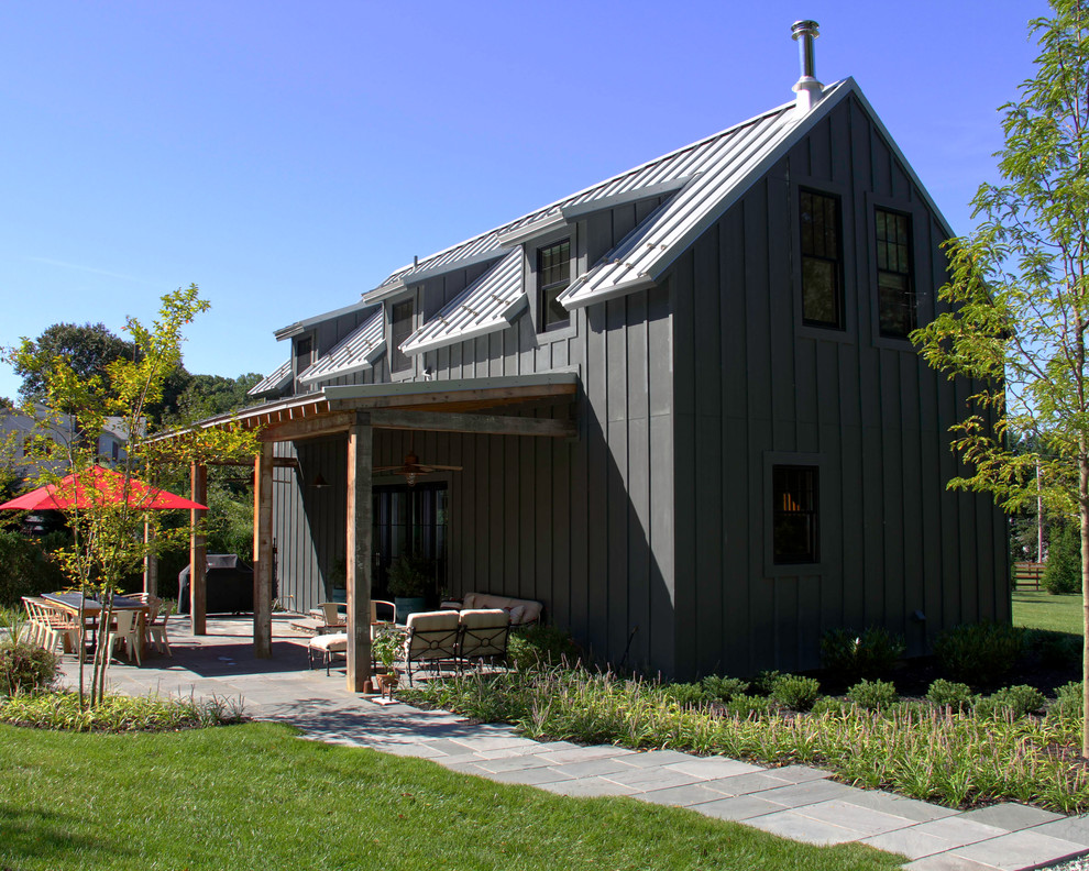 Modelo de fachada gris de estilo de casa de campo pequeña de dos plantas con revestimiento de aglomerado de cemento