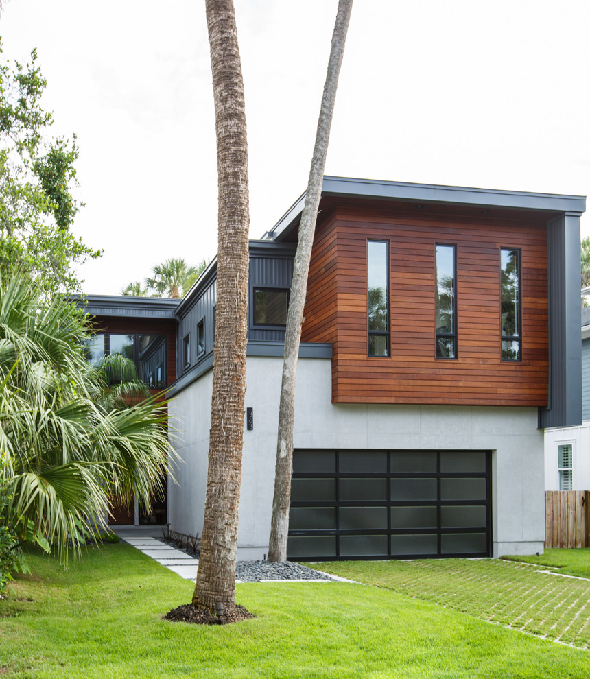 Ejemplo de fachada de casa actual de tamaño medio de dos plantas con revestimiento de madera y tejado plano