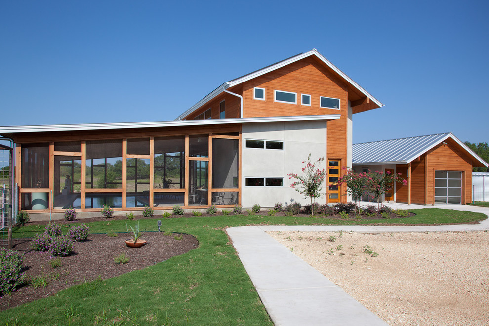 Imagen de fachada de casa minimalista de dos plantas con revestimiento de madera y tejado de metal