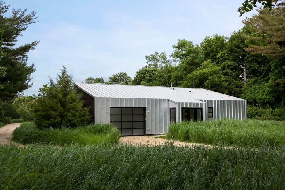 Idée de décoration pour une façade de maison métallique et grise minimaliste de taille moyenne et de plain-pied avec un toit en appentis et un toit en métal.
