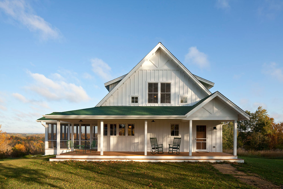 Idée de décoration pour une façade de maison blanche champêtre en bois à un étage avec un toit à deux pans.