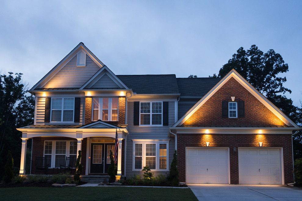 Cette photo montre une grande façade de maison beige chic à un étage avec un revêtement mixte et un toit à quatre pans.