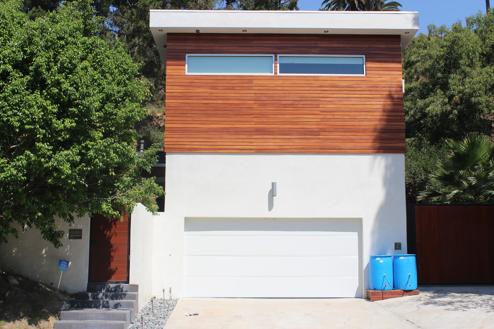 Imagen de fachada minimalista pequeña de dos plantas con revestimientos combinados y tejado plano