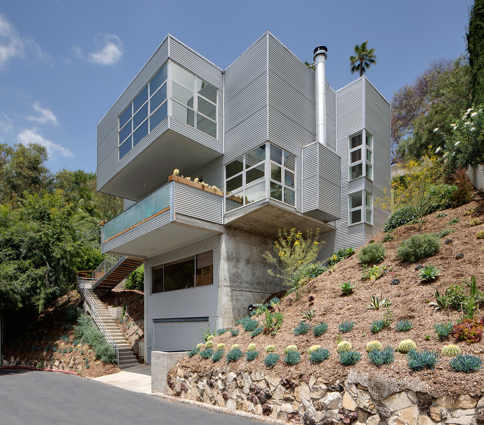 Ispirazione per la facciata di una casa verde industriale a tre piani con rivestimento in metallo e tetto piano