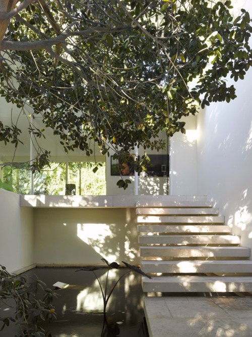На фото: одноэтажный, белый дом среднего размера в стиле модернизм с облицовкой из цементной штукатурки и плоской крышей