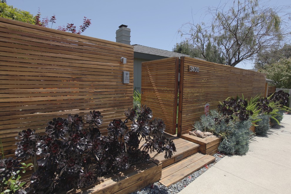 Medium sized and gey eclectic bungalow house exterior in Los Angeles with wood cladding.