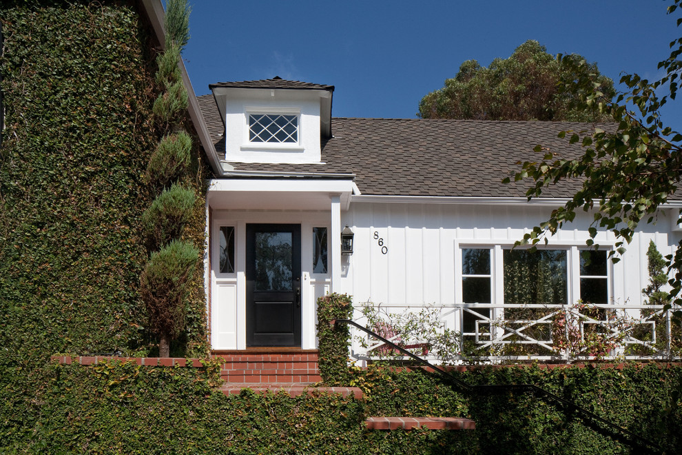 This is an example of a white and medium sized traditional bungalow house exterior in Los Angeles with wood cladding and a pitched roof.