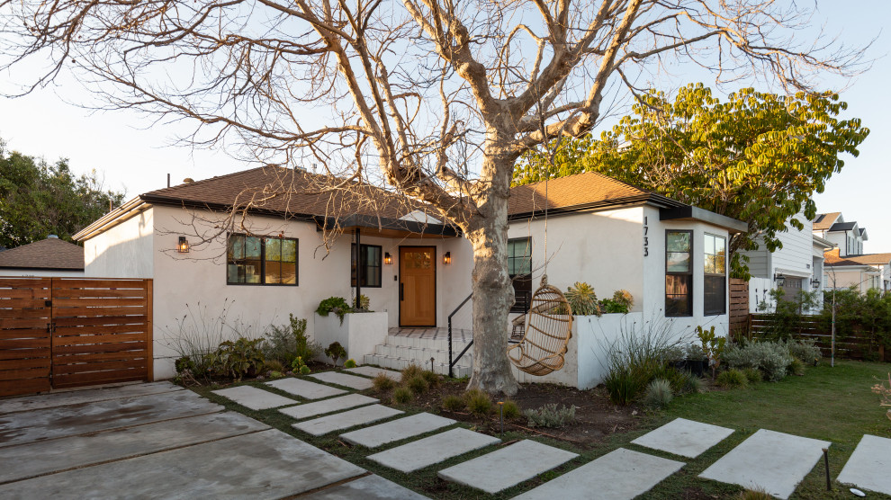 На фото: одноэтажный, белый частный загородный дом среднего размера в современном стиле с облицовкой из цементной штукатурки, вальмовой крышей и черепичной крышей