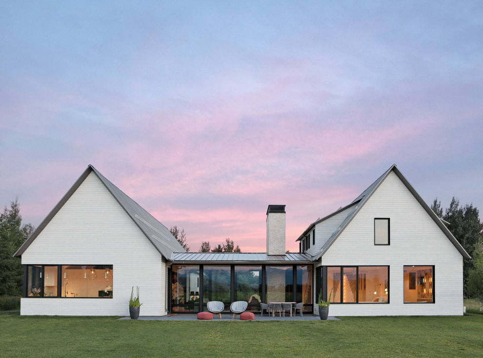 Immagine della villa bianca country a un piano con tetto a capanna e copertura in metallo o lamiera