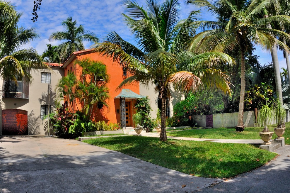 マイアミにあるトロピカルスタイルのおしゃれな二階建ての家 (オレンジの外壁) の写真