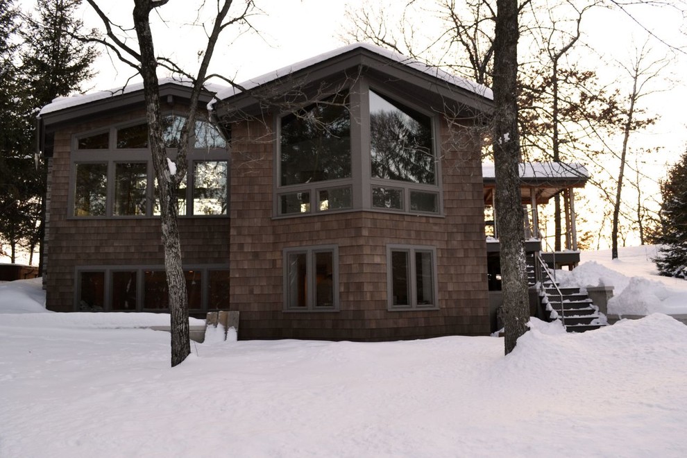 Esempio della facciata di una casa contemporanea a due piani con rivestimento in legno