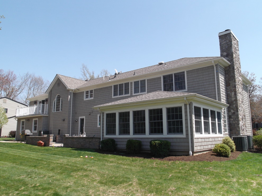 Inspiration for a large timeless gray two-story mixed siding exterior home remodel in New York with a clipped gable roof