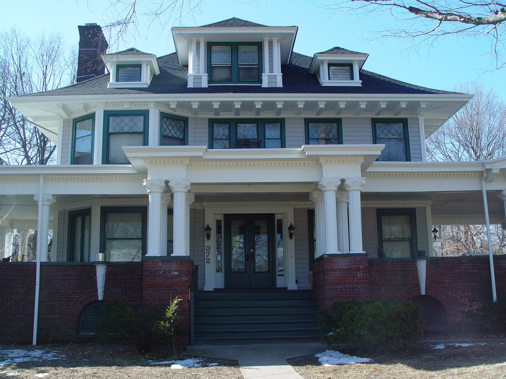 Example of a mid-sized classic gray three-story mixed siding gable roof design in New York