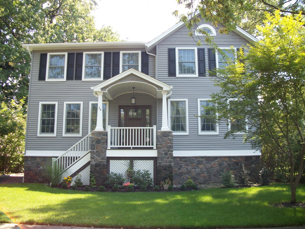 Пример оригинального дизайна: двухэтажный, серый дом среднего размера в классическом стиле с комбинированной облицовкой и двускатной крышей