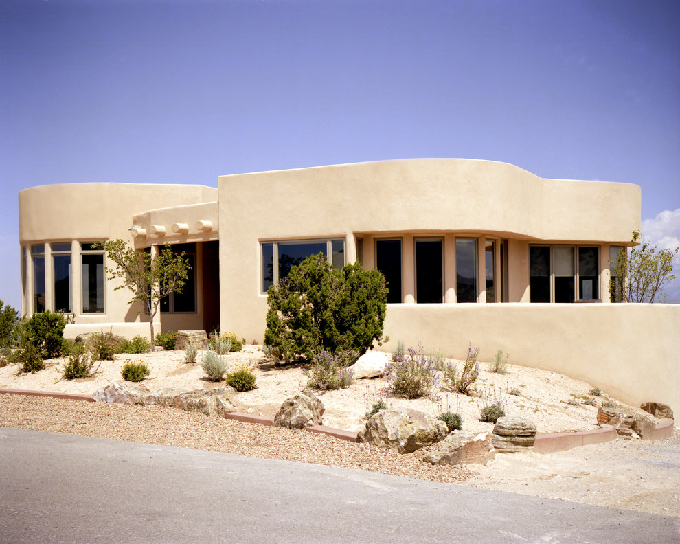 Cette photo montre une grande façade de maison blanche moderne en adobe à un étage avec un toit plat.