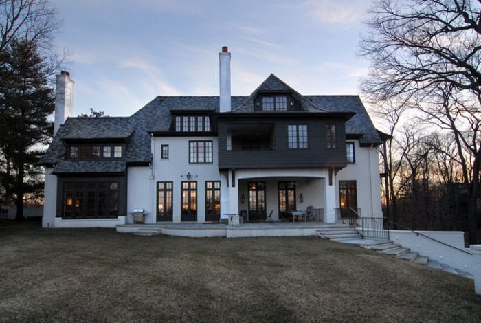 Cette photo montre une grande façade de maison blanche à un étage avec un revêtement mixte et un toit à deux pans.