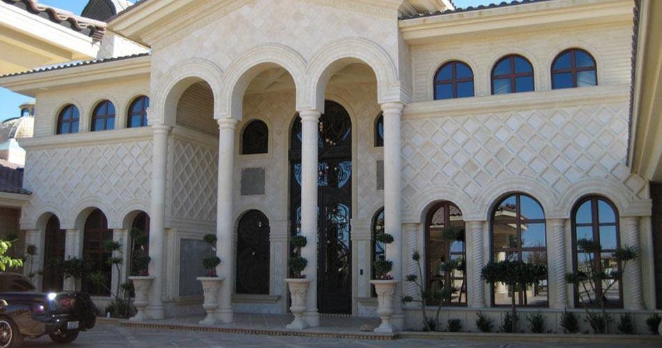 Diseño de fachada beige mediterránea extra grande de dos plantas con revestimiento de piedra