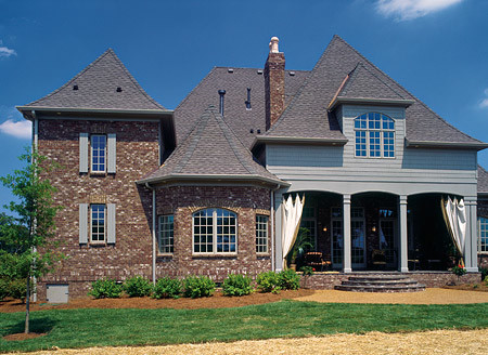 Esempio della facciata di una casa multicolore classica a due piani di medie dimensioni con rivestimento in mattoni e tetto a padiglione