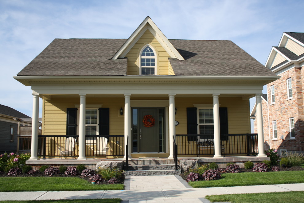 Example of a small arts and crafts white one-story wood house exterior design in Toronto with a hip roof and a shingle roof