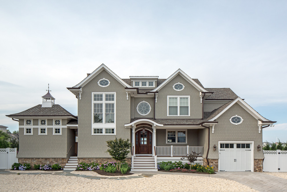 Cette photo montre une façade de maison grise bord de mer en bois à un étage avec un toit à deux pans et un toit en shingle.