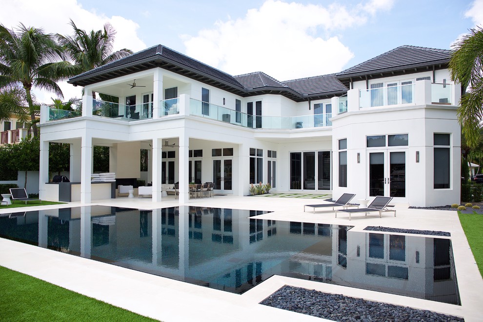 Großes, Zweistöckiges Klassisches Haus mit Betonfassade, weißer Fassadenfarbe und Halbwalmdach in Miami