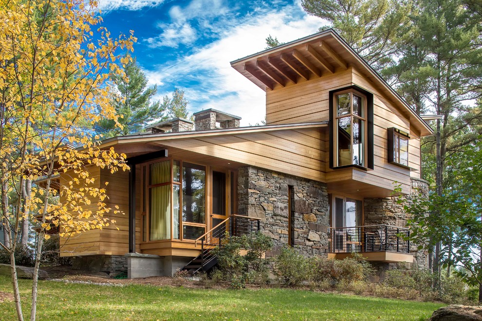 Diseño de fachada marrón moderna grande de tres plantas con revestimiento de madera y tejado de un solo tendido