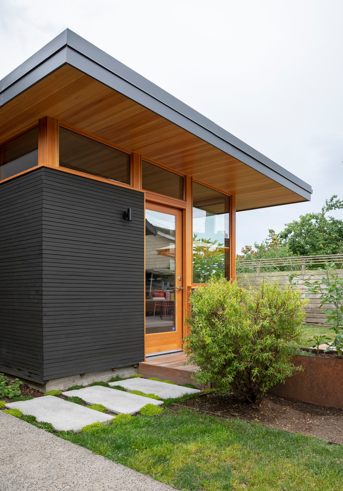 Идея дизайна: двухэтажный, деревянный, черный частный загородный дом среднего размера в стиле модернизм с односкатной крышей