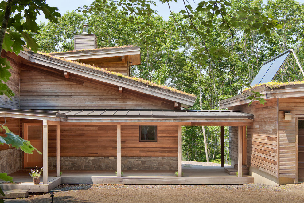 Cette image montre une grande façade de maison marron design en bois avec un toit en appentis.