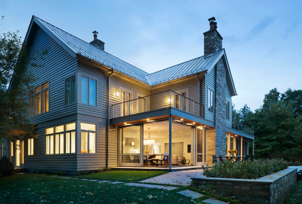 Ejemplo de fachada beige moderna de dos plantas con tejado a dos aguas y revestimiento de madera