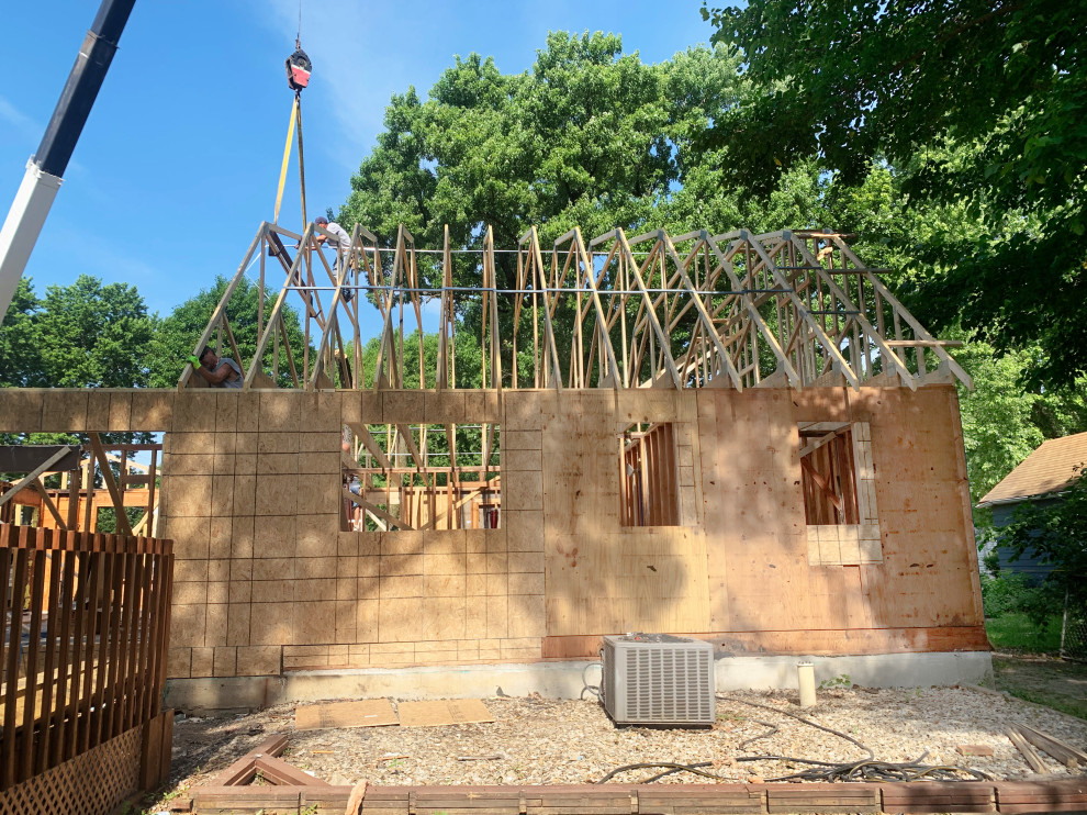 Idée de décoration pour une grande façade de maison bleue champêtre en bois à deux étages et plus avec un toit en appentis et un toit en shingle.