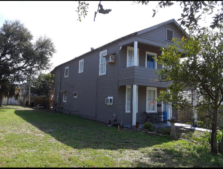 This is an example of a large and gey classic two floor side semi-detached house in Houston with concrete fibreboard cladding, a shingle roof, a red roof and board and batten cladding.