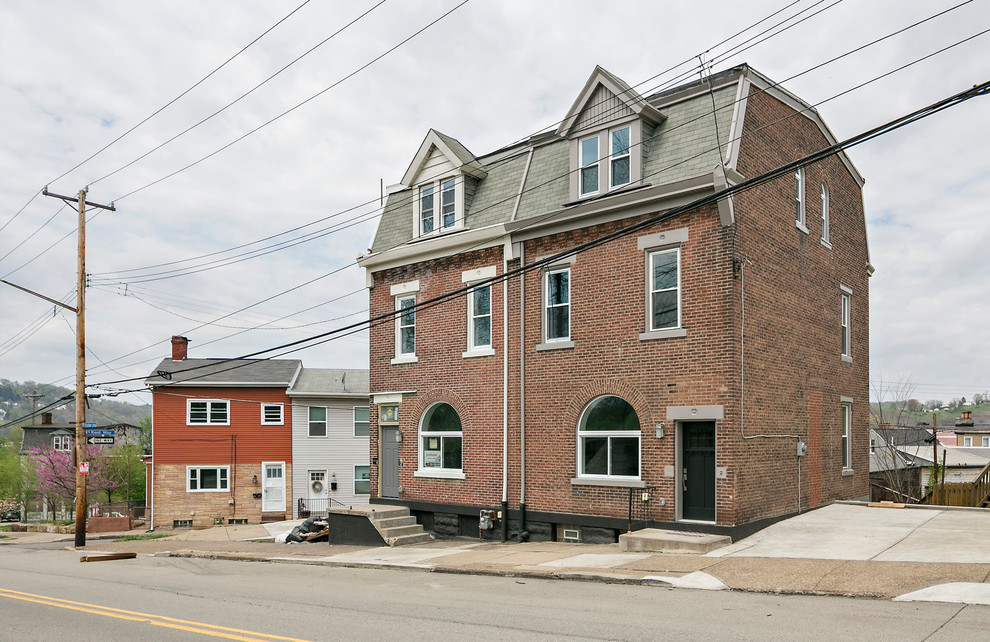 Foto de fachada de casa bifamiliar roja industrial de tamaño medio de tres plantas con revestimiento de ladrillo, tejado plano y tejado de teja de madera