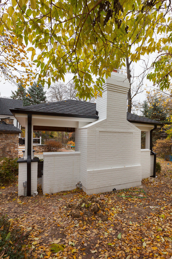 Réalisation d'une grande façade de maison blanche tradition en brique à un étage avec un toit en shingle.