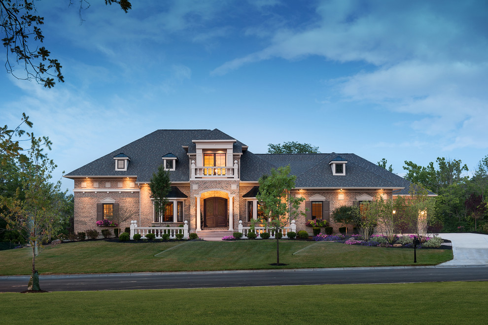 Large elegant beige one-story brick house exterior photo in Cincinnati with a hip roof and a shingle roof