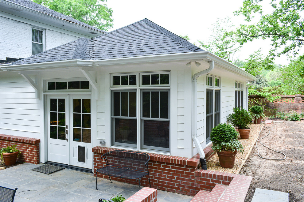 Réalisation d'une façade de maison blanche champêtre de taille moyenne et à un étage avec un revêtement mixte, un toit à quatre pans et un toit en shingle.
