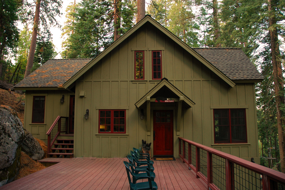 Imagen de fachada de casa verde rústica de tamaño medio a niveles con revestimiento de aglomerado de cemento, tejado a dos aguas y tejado de teja de madera