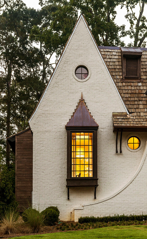 Diseño de fachada blanca clásica de dos plantas con revestimiento de ladrillo y tejado de teja de madera