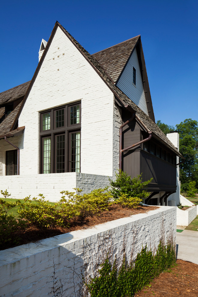 Ejemplo de fachada de casa blanca tradicional renovada de tamaño medio de dos plantas con revestimiento de ladrillo, tejado a dos aguas y tejado de teja de madera