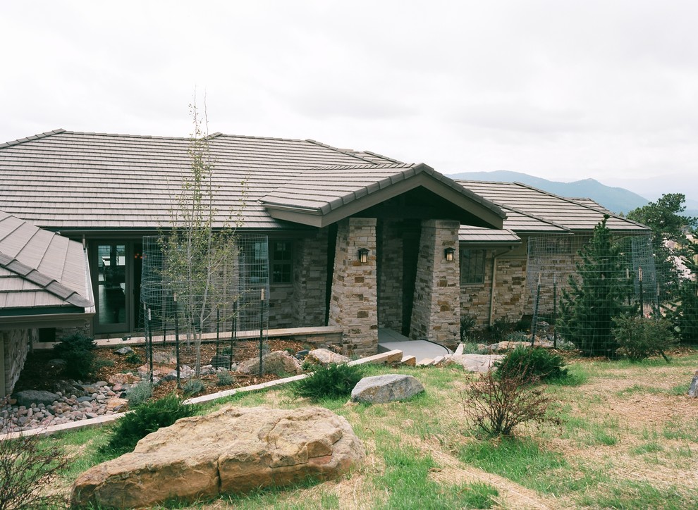 Inspiration for a large and beige rustic bungalow house exterior in Denver with stone cladding.