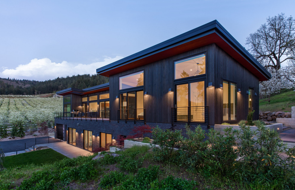Mittelgroßes, Zweistöckiges Modernes Haus mit schwarzer Fassadenfarbe, Pultdach und Blechdach in Portland