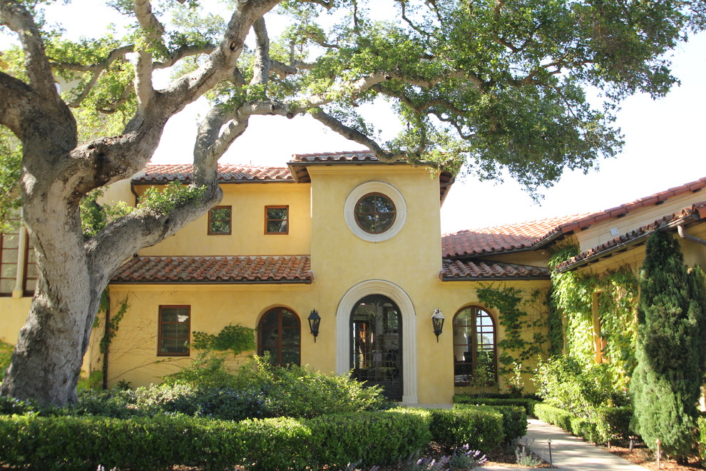Großes, Dreistöckiges Mediterranes Einfamilienhaus mit Putzfassade, gelber Fassadenfarbe, Walmdach und Ziegeldach in Santa Barbara
