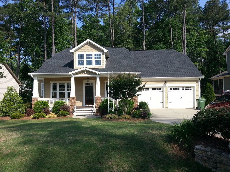 Mid-sized elegant beige two-story vinyl exterior home photo in Raleigh with a hip roof
