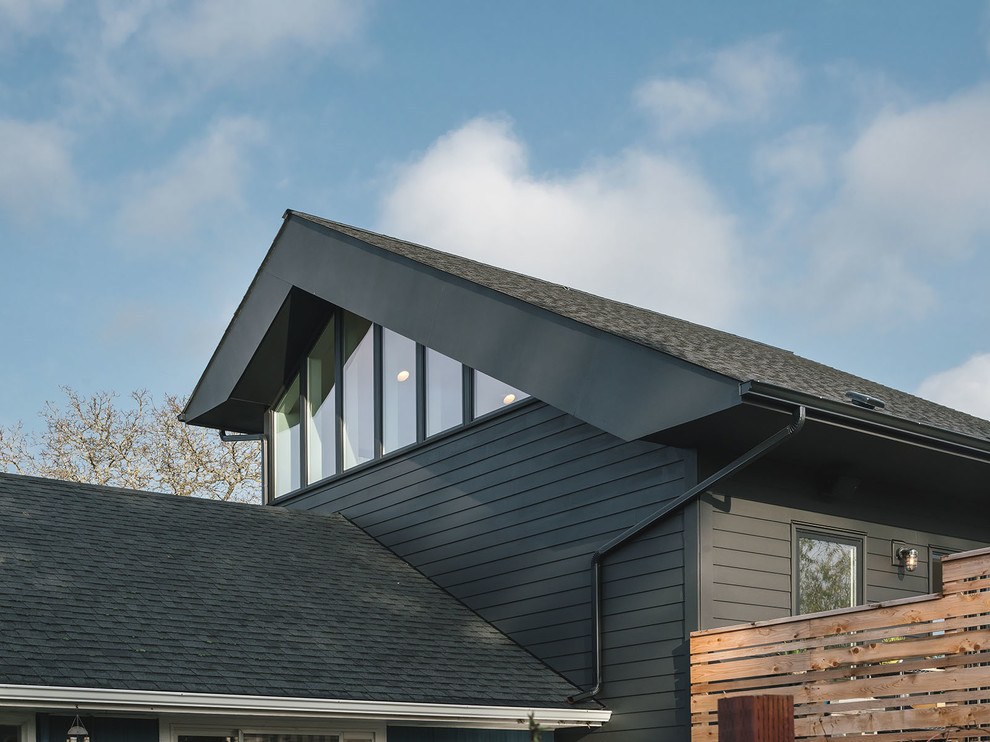 Photo of a medium sized and black modern two floor detached house in Portland with wood cladding, a pitched roof and a shingle roof.