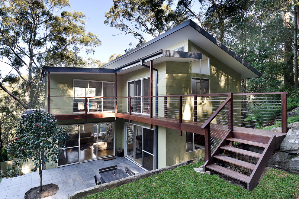 Réalisation d'une grande façade de maison verte design en panneau de béton fibré à deux étages et plus avec un toit plat.