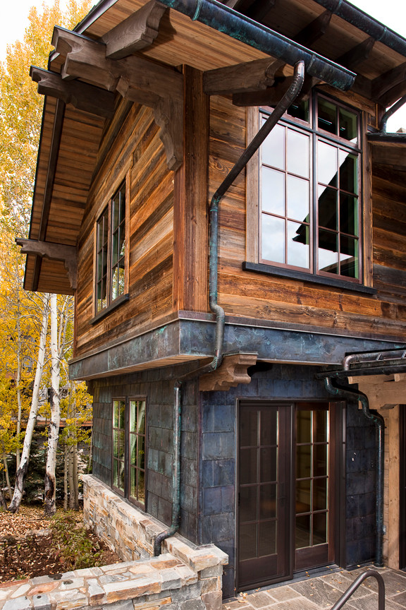 Réalisation d'une grande façade de maison design en bois à un étage.