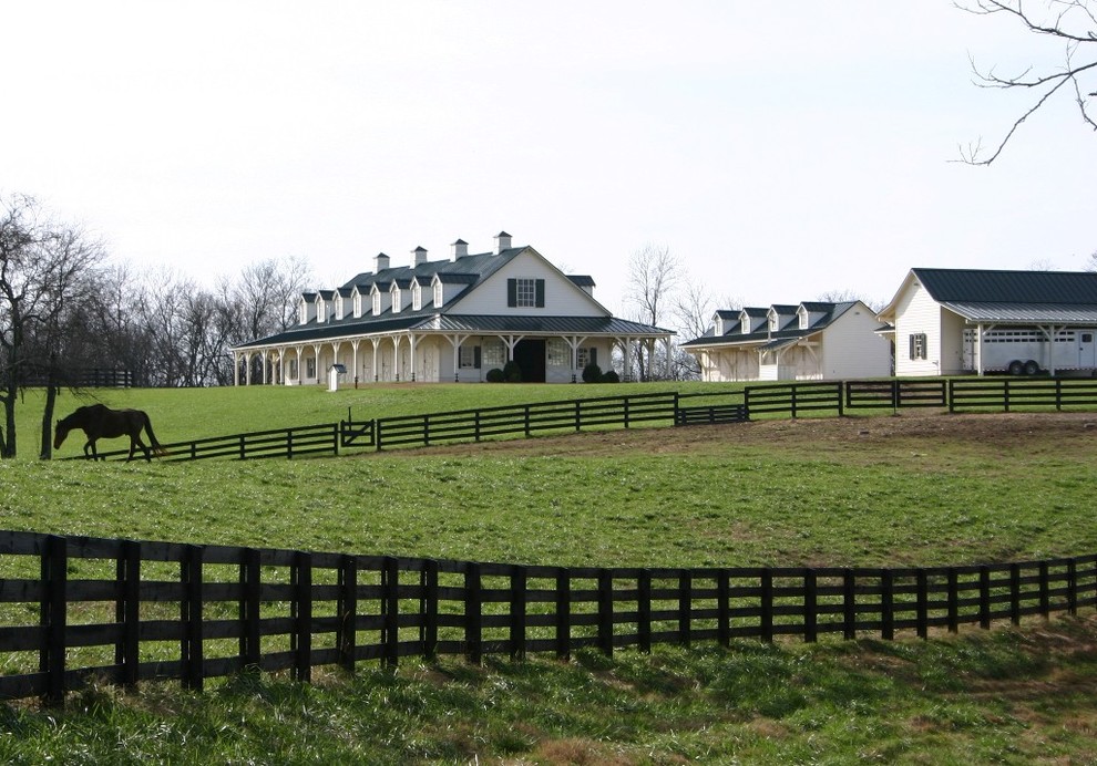 This is an example of a large rural two floor house exterior in Nashville with wood cladding.