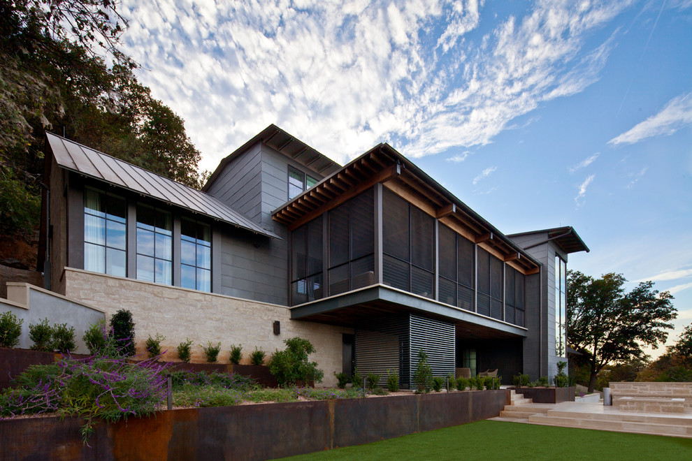 На фото: огромный, трехэтажный дом в стиле неоклассика (современная классика) с облицовкой из металла и двускатной крышей с